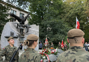 grupa osób podczas uroczystości przed Pomnikiem Ofiar Komunizmu w  Łodzi